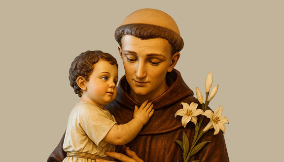 A photograph depicts a statue of St. Anthony tenderly cradling Infant Jesus in his arms.